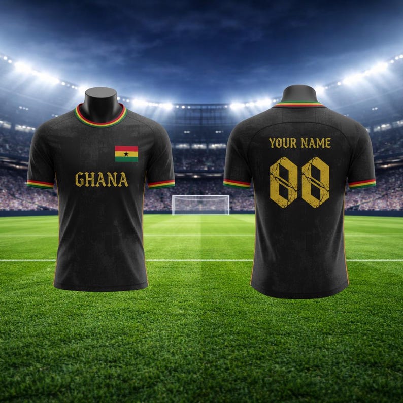May include: Black football shirt with the word "Ghana" and the Ghana flag on the front. The back of the shirt has the number "00" and the words "YOUR NAME". The shirt has green, yellow, and red trim.