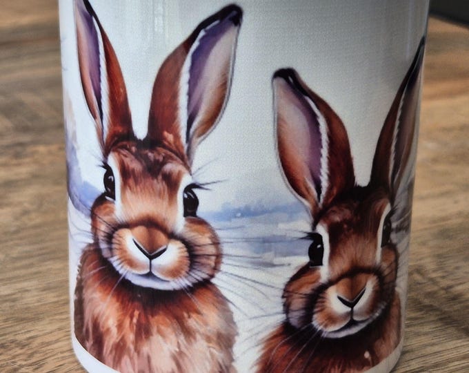 Featured listing image: Rabbits in a winter landscape on a ceramic mug. The mug is printed all over.