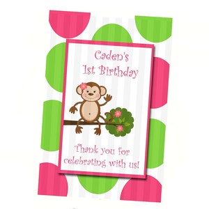 May include: A pink and green polka dot background with a white card in the center. The card has a monkey illustration and the text "Caden's 1st Birthday" and "Thank you for celebrating with us!"
