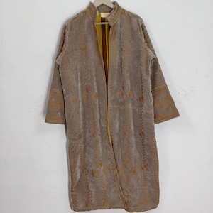 May include: A long-sleeved, taupe-colored velvet coat featuring a high collar and vertical embroidery patterns in a matching thread. The interior lining is a vibrant mustard yellow with brown vertical stripes, visible at the open front opening.