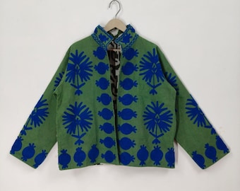 May include: A green jacket with blue embroidered floral patterns. The jacket has a mandarin collar and long sleeves. The interior lining features a black and white pattern. The jacket is hanging on a hanger.