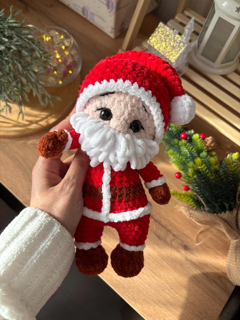 Puede incluir: Mu&ntilde;eco de Pap&aacute; Noel de ganchillo, rojo y blanco. El gorro y la barba son blancos, mientras que los brazos, las piernas y el cintur&oacute;n son marrones. La cara sonriente y los ojos negros completan este personaje navide&ntilde;o, ideal para las fiestas.