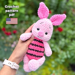 Könnte beinhalten: Ein rosa gehäkeltes Hasenplüschtier mit einem schwarz-rosa gestreiften Bauch. Das Plüschtier hat große rosa Ohren, schwarze Augen und eine kleine rosa Nase. Der Text im Bild lautet "Crochet pattern pdf" mit einer amerikanischen Flagge.