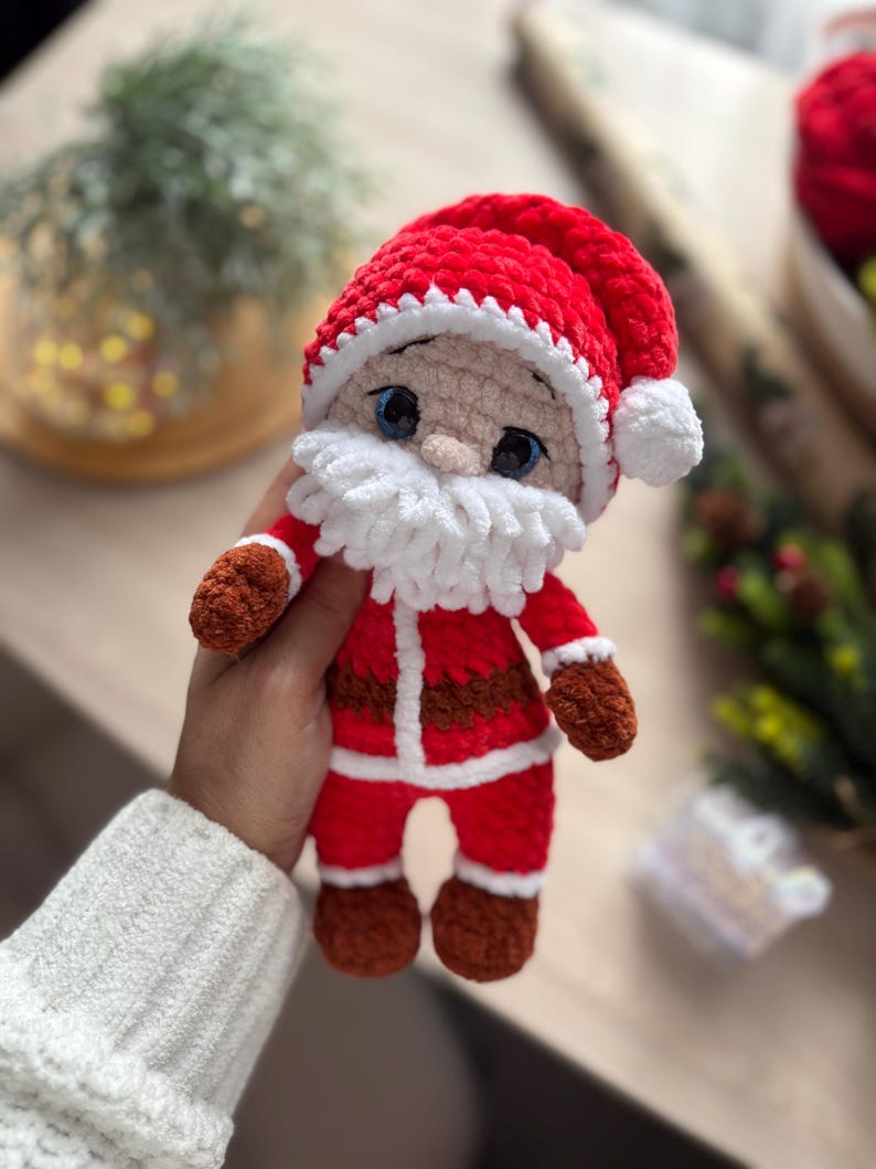 Puede incluir: Mu&ntilde;eco de Pap&aacute; Noel tejido a mano en rojo y blanco. El mu&ntilde;eco tiene un gorro rojo con ribete y pomp&oacute;n blancos, barba blanca y guantes y botas marrones. El mu&ntilde;eco mide aproximadamente 15 cm de alto.