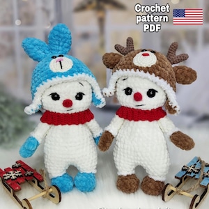Puede incluir: Dos muñecos de nieve de ganchillo, uno con gorro de conejito azul y otro con gorro de reno marrón. Ambos tienen bufandas rojas, ojos negros y narices rojas. La imagen incluye el texto "Crochet pattern PDF".