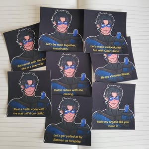 May include: Several square art prints showcasing a cartoon character with dark hair, a blue mask, and a thumbs-up. Each print displays a different humorous phrase in white text, including "Let's be toxic together, sustainably."