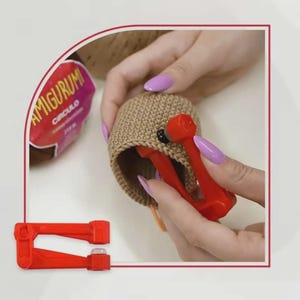 Op de afbeelding: Een beige gehaakte bol die wordt voorzien van een zwart plastic veiligheidsoogje met behulp van een rood handmatig applicatiegereedschap. Een bol bruin Amigurumi Circulo garen is op de achtergrond zichtbaar en een tweede rode applicator ligt vooraan.