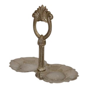 Peut inclure: Plat à deux niveaux de couleur argentée avec une poignée ornée. Le plat comporte deux plateaux de forme ovale reliés par une tige centrale. La poignée présente un motif décoratif en volutes. Une pièce classique pour servir des amuse-gueules ou des desserts.