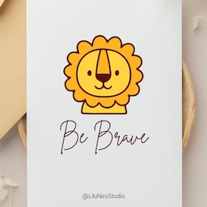 May include: A white card with a cartoon lion illustration in yellow and brown. The text "Be Brave" is written in a cursive font below the lion. The artist's name, "@LiluNesiStudio", is at the bottom.