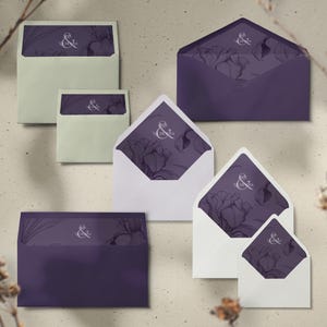 May include: An assortment of envelopes in various sizes, featuring a floral design and the text "&" in white. The envelopes are in shades of purple and white, with a light beige background.