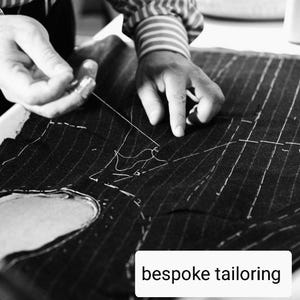 May include: A monochrome image showing a tailor sewing pinstripe fabric. The tailor's hands are visible, working with a needle and thread. The text "bespoke tailoring" is displayed in a white box at the bottom of the image.