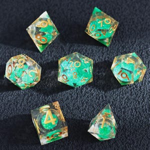 Conjunto de dados com núcleo líquido verde, resina transparente com números e detalhes em dourado, 7 dados com bordas afiadas e glitter para D&D