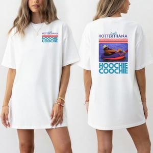 May include: White t-shirt with the text "It gets HOTTERthana HOOCHIE COOCHIE" in blue and red. The back of the shirt features a graphic of a person in a tube on the water with the same text.