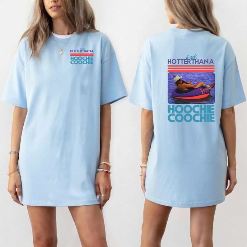 May include: Light blue t-shirt with the text "HOTTERTHANA HOOCHIE COOCHIE" on the front. The back of the shirt features a graphic of a person in a tube with the text "It gets HOTTERTHANA HOOCHIE COOCHIE".
