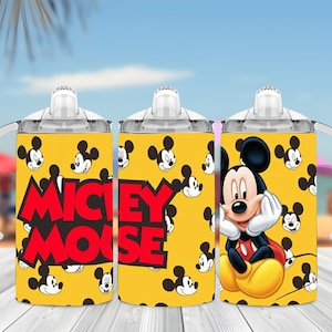 Puede incluir: Un vaso con boquilla amarillo con un patr&oacute;n repetitivo de cabezas de Mickey Mouse, tapa transparente y asas blancas. El texto MICKEY MOUSE aparece en letras rojas grandes en el lateral, junto a una ilustraci&oacute;n de Mickey Mouse apoyando su barbilla.