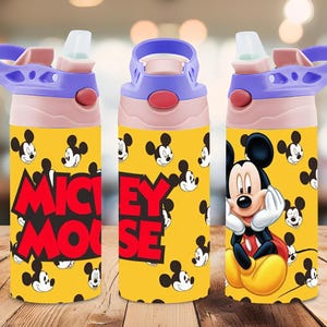 Puede incluir: Una botella de agua amarilla con un patr&oacute;n repetitivo de cabezas de Mickey Mouse y el texto MICKEY MOUSE en letras rojas negritas. La botella tiene un cuello rosa claro, una tapa morada con asa y una boquilla de pajita abatible transparente.