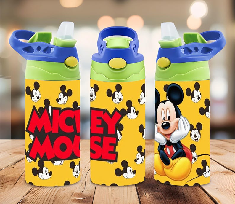 Puede incluir: Una botella de agua amarilla con un patr&oacute;n repetitivo de Mickey Mouse, el texto MICKEY MOUSE en letras rojas grandes y un gr&aacute;fico m&aacute;s grande de Mickey Mouse. La tapa azul y verde lima tiene una boquilla de pl&aacute;stico transparente y un asa.