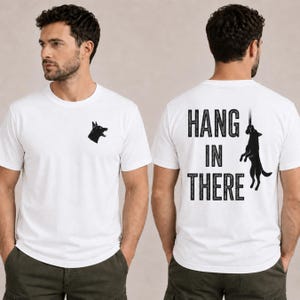 May include: White t-shirt with a black dog head graphic on the front and the words "HANG IN THERE" with a dog graphic on the back. The shirt is short-sleeved and made of a soft material.