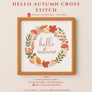 Könnte beinhalten: Ein gerahmtes Kreuzstichmuster mit dem Text "Hello Autumn", umgeben von einem Kranz aus Herbstblättern und Pilzen. Der Rahmen ist hellbraun. Der Text "Hello Autumn Cross Stitch" steht oben.