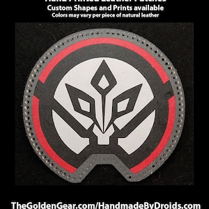 Puede incluir: Un parche de cuero negro y blanco con un borde rojo. El parche presenta un diseño geométrico estilizado con un punto central y cuatro puntos circundantes. El texto "Hand Printed Leather Patches" está en la parte superior de la imagen. El texto "Custom Shapes and Prints available" está debajo de la primera línea de texto. El texto "Colors may vary per piece of natural leather" está debajo de la segunda línea de texto. El texto "TheGoldenGear.com/HandmadeByDroids.com" está en la parte inferior de la imagen.
