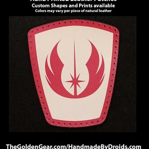 May include: A white leather patch with a red Jedi symbol, featuring a star and wings. The patch has a red stitched border and is hand-printed. TheGoldenGear.com/HandmadeByDroids.com
