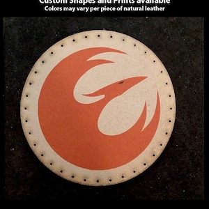 Könnte beinhalten: Handbedruckter Lederaufnäher in runder Form mit rotem und weißem Design und einer genähten Umrandung. Der Text "Hand Printed Leather Patches" ist sichtbar. Individuelle Formen und Drucke sind verfügbar.