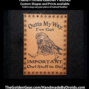 May include: A brown leather patch with a black owl illustration and the text "Outta My Way I've Got IMPORTANT Owl Stuff to Do!" The patch is surrounded by a row of metal rivets.