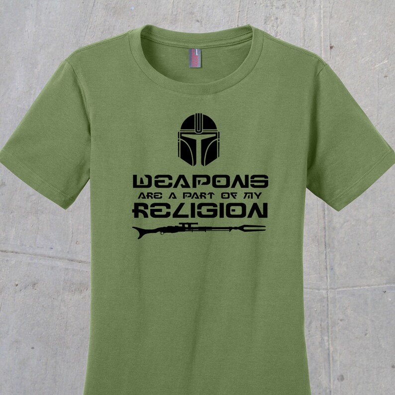 May include: A green t-shirt with a black graphic of a Mandalorian helmet and the text "Weapons are a part of my religion".