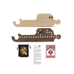 Può includere: Due tavolieri da gioco in legno a forma di sottomarino, uno chiaro e uno scuro, con file di fori per le biglie. Include un sacchetto nero con coulisse pieno di biglie colorate, un foglio di istruzioni stampato e un mazzo di carte Bicycle.