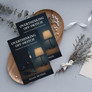 Pu&ograve; includere: Due libri intitolati "OVERTHINKING OFF-SWITCH" con il sottotitolo "A gentle off-switch for a loud mind" sono esposti su un vassoio di legno. Le copertine dei libri presentano un'illustrazione di una lampada. Il nome dell'autore, ELIAN MUNEER, &egrave; visibile.