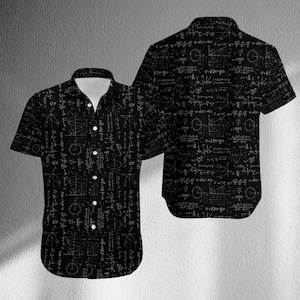 Può includere: Camicia nera a maniche corte con colletto bianco e un motivo ripetuto di equazioni e simboli matematici bianchi. La camicia ha un colletto classico e bottoni bianchi. Un'altra camicia è visibile dietro la prima.