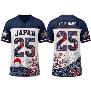 May include: A navy blue and white V-neck jersey featuring the text JAPAN and the number 25 on the front, with a graphic of Mount Fuji and cherry blossoms. The back displays the number 25 and a nameplate with the text YOUR NAME.
