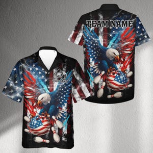 Puede incluir: Una camisa de manga corta con un diseño patriótico. Presenta un águila, bolos y una bola de bolos con la bandera estadounidense. El fondo es negro con detalles en rojo, blanco y azul. Los textos "TEAM NAME" y "YOUR NAME" son visibles.