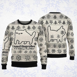 Könnte beinhalten: Ein grau-weißer Langarm-Strickpullover mit einer schwarzen Katzengrafik und dem Text "I need ibuprofen" sowie japanischen Schriftzeichen darunter. Der Pullover hat ein wiederkehrendes Muster aus schwarzen Schneeflocken und einen schwarzen Rundhalsausschnitt.