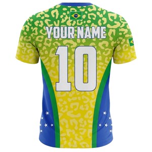 May include: A Brazil-themed jersey with a yellow and green leopard print design. The jersey features the text "YOUR NAME" above the number "10" in white. The jersey has blue accents and the Brazilian flag.