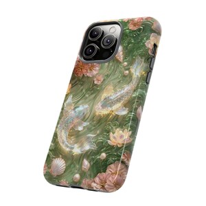 Angled product view of a green floral koi fish phone case on white, showing the square camera opening, black edge and printed back.