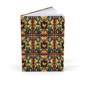 May include: Hardback journal with a vibrant geometric pattern of corn stalks and chickens in shades of blue, yellow, and brown. The journal is open, displaying blank white pages.