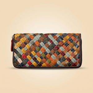 Puede incluir: Una cartera rectangular con un patrón trenzado multicolor de tiras de cuero en tonos amarillo, naranja, rojo, verde, azul y marrón. La cartera tiene un borde de cuero marrón oscuro y una cremallera a juego del mismo color en el lateral.