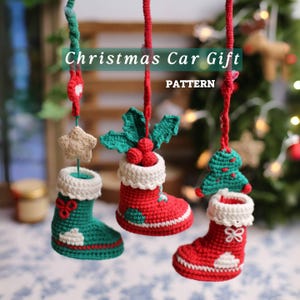 May include: Crocheted Christmas car gift decorations in red, green, and white. The decorations include a star, a Christmas tree, and a stocking. The text "Christmas Car Gift" and "PATTERN" are visible in the image.