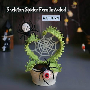 May include: A crocheted Halloween decoration with a white spider web inside a green fern-like frame. Black spiders with skull and eyeball details are placed around the web and pot. The text "Skeleton Spider Fern Invaded" and "PATTERN" are visible.