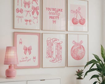 May include: A collection of framed pink art prints featuring bows, cherries, cowboy boots, and a disco ball. One print reads "You're like really pretty." A pink lamp sits on a white dresser below the art.