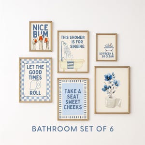 Op de afbeelding: Een set van zes ingelijste badkamerkunstprints met gouden frames. De prints bevatten grillige illustraties en tekst, waaronder zinnen als "Nice Bum" en "Take a Seat Sweet Cheeks". Het kleurenschema is blauw en crème.