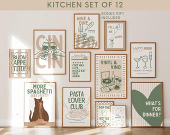 May include: A set of twelve wall art prints featuring kitchen and dining themes in a muted green and beige color palette. The prints include illustrations of wine glasses, pasta, a cat eating spaghetti, a record player, and text like "Cin Cin", "Wine & Dine", "Pasta Lover Club", and "What's For Dinner?" displayed in various frames.