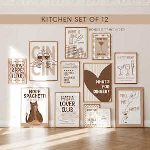May include: A set of twelve wall art prints featuring kitchen and dining themes in brown and beige tones. The prints include illustrations of wine glasses, pasta, a cat eating spaghetti, and text such as "Wine & Dine," "Pasta Lover Club," and "What's for dinner?" displayed in wooden frames.