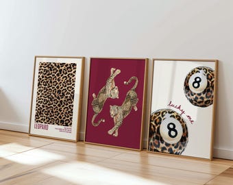 May include: Three framed art prints with a wooden frame. The first print features a leopard print pattern with the word "LEOPARD". The second print has two leaping leopard illustrations on a burgundy background. The third print shows two pool balls with the number 8 and the words "lucky me".