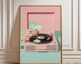 May include: A framed print featuring a pink record player with a black vinyl record. A hand with red nail polish and rings holds a cocktail with a lime garnish. The background is pink and teal.