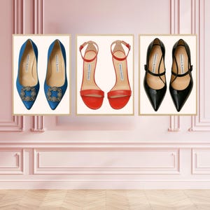 Puede incluir: Tres impresiones enmarcadas de zapatos de mujer. Las impresiones presentan zapatos de salón azules de satén con hebillas enjoyadas, sandalias rojas con tiras y zapatos de salón negros de charol con correas en el tobillo. Fondo rosa.