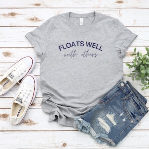 Cute lake day tee paired with cutoffs and sneakers, perfect summer uniform for chill float vibes.