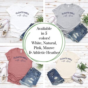 Peut inclure: Plusieurs t-shirts de couleurs blanche, grise, rose, naturelle et mauve, avec l'inscription "FLOATS WELL with others" en bleu marine. Les t-shirts sont pr&eacute;sent&eacute;s avec des shorts en jean et des baskets.