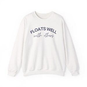 Cozy fleece crewneck with navy script print, styled for warm weather layering, float brunch, or lake house lounging.